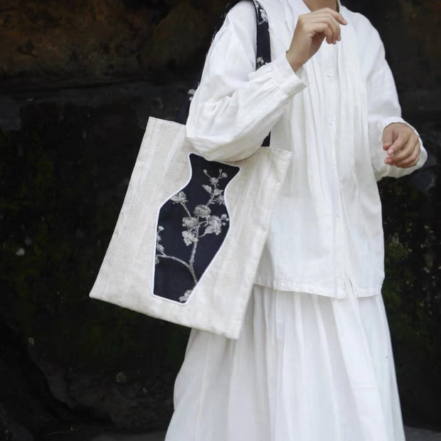 A stylish woman carrying The Black Blossom Tote, a sophisticated canvas bag featuring an interactive floral vase pocket.