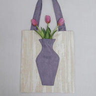 Close-up of The purple Blossom Tote, integrated pocket holding a fresh pink flower