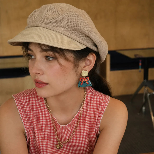 Model wearing Kitty Bow Statement Earrings with cream cat studs, red bows and teal polka-dot drops