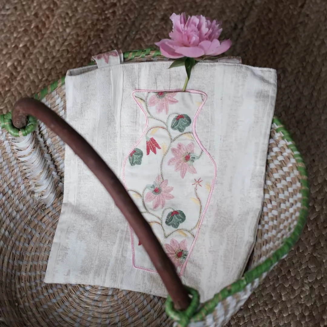 Close-up of the embroidered vase pocket on The Pink Blossom Tote with real flowers inside.
