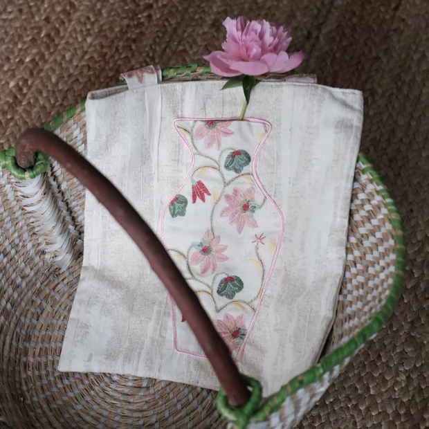 Close-up of the embroidered vase pocket on The Pink Blossom Tote with real flowers inside.