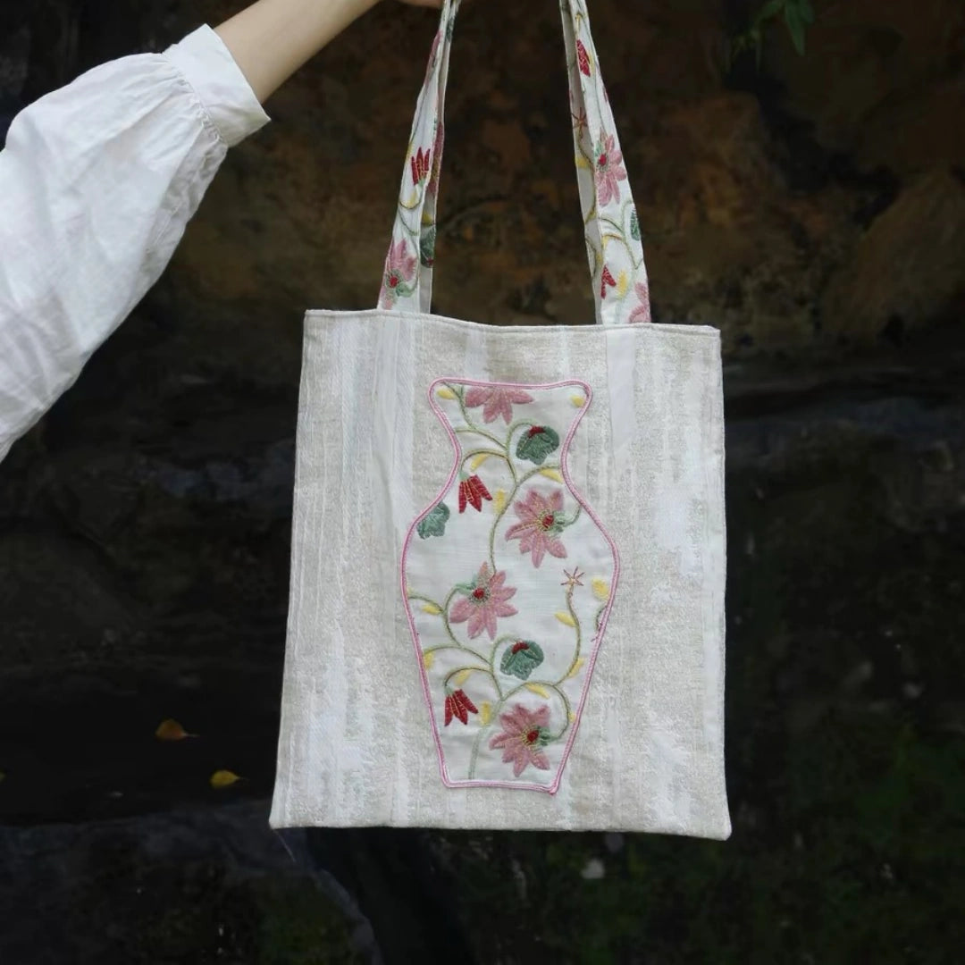 Close-up of the embroidered vase pocket on The Pink Blossom Tote with real flowers inside.