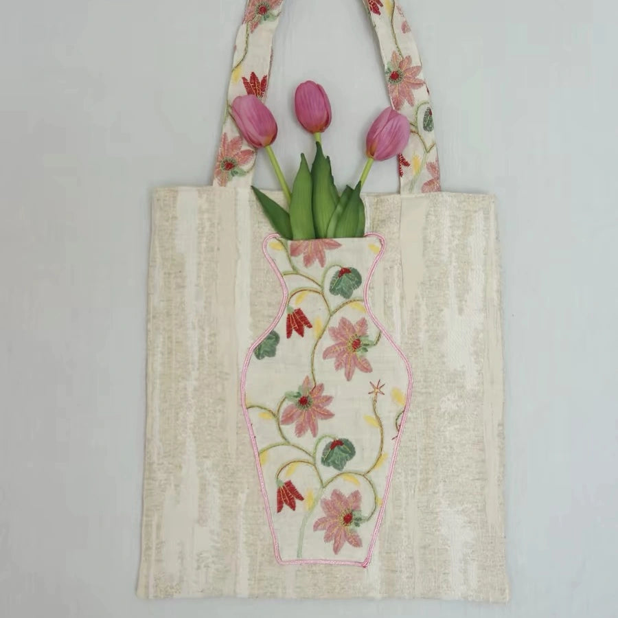 Close-up of the embroidered vase pocket on The Pink Blossom Tote with real flowers inside.